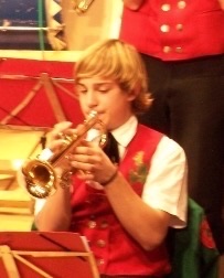 Elias, age 10, playing trumpet in the orchestra